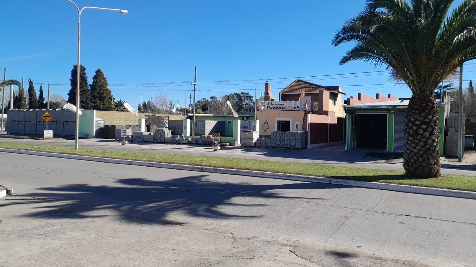 Frente de la Bloquera El Pochito en Sierra Chica, con pallets de bloques en la vereda